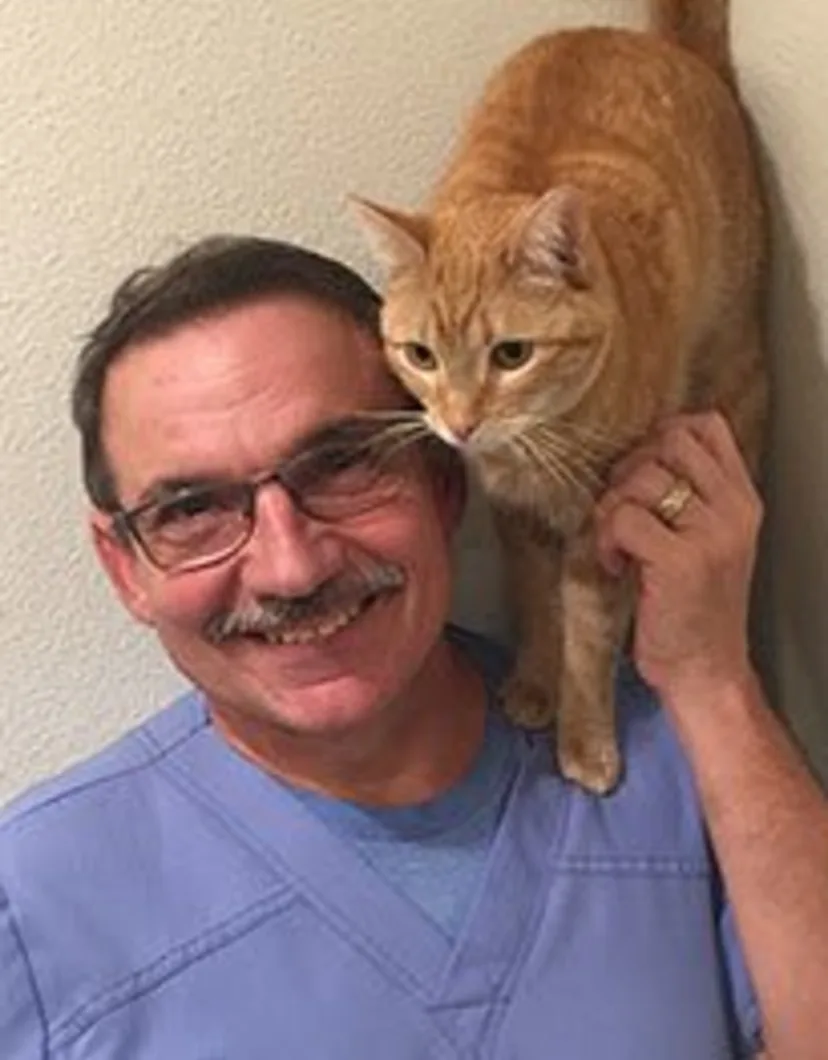 Doug with an orange cat standing on his shoulder